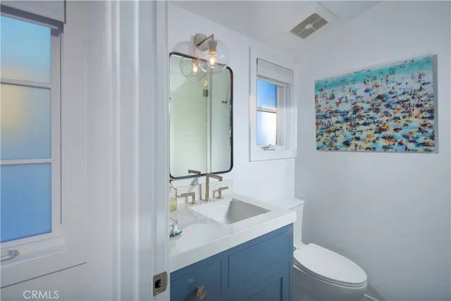 a bathroom with a granite countertop toilet sink and mirror