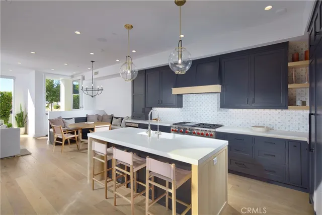a kitchen with a dining table chairs sink and white cabinets
