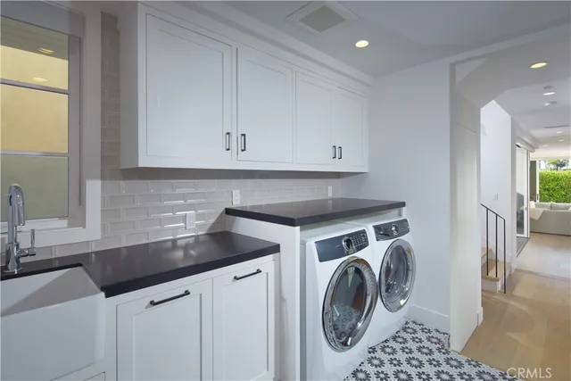a utility room with sink dryer and washer