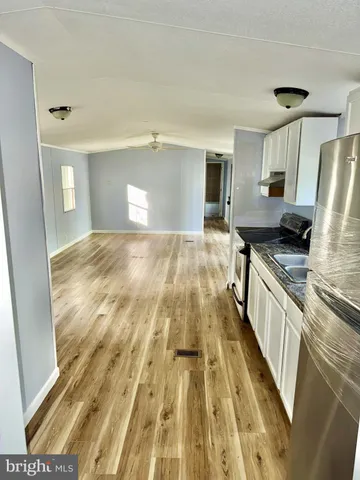 a kitchen with a stove white cabinets and refrigerator