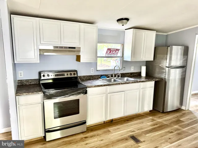 a kitchen with granite countertop a stove and a refrigerator