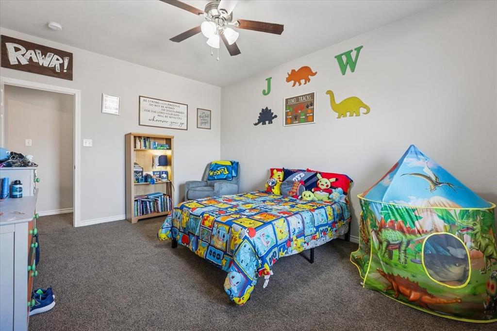 868 Valley Ridge Road Burleson, TX 76028 - Photo 27 of 40 a bedroom with a bed and a baby bed