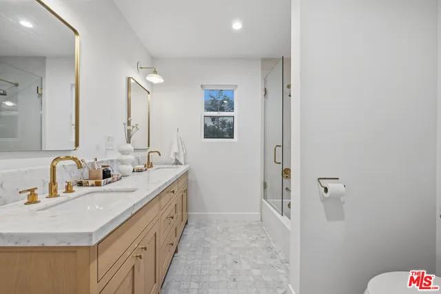 a bathroom with double vanity sink and a mirror