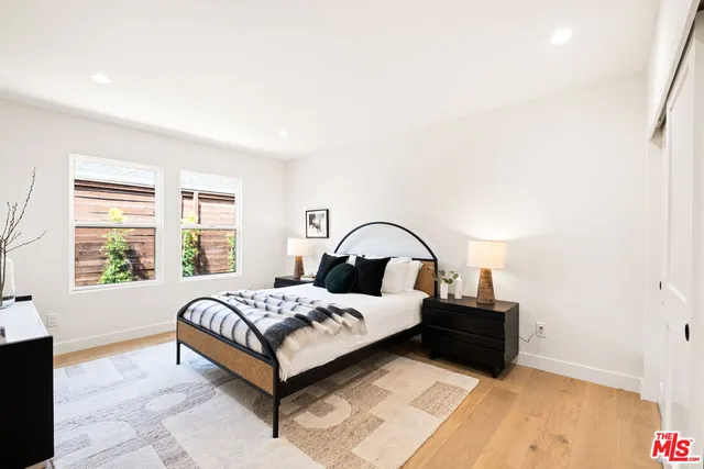 a bedroom with a bed lamp closet and window