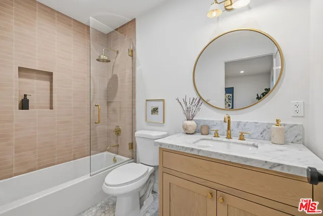 a bathroom with a granite countertop toilet a sink and a mirror