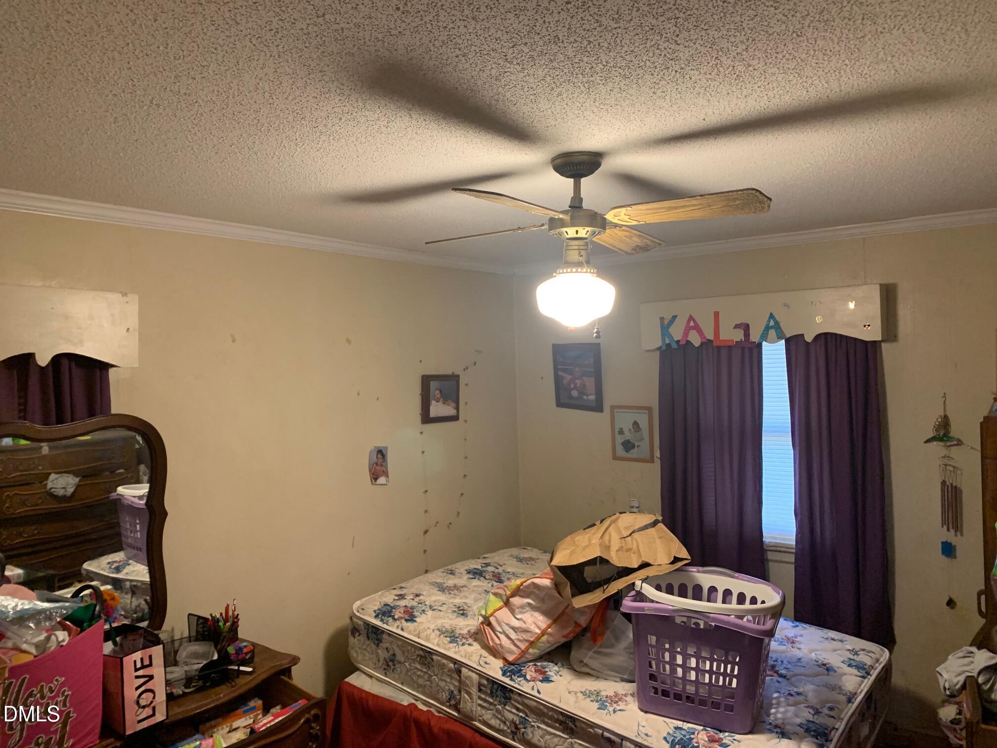438 Dudley Street Burlington, NC 27217 - Photo 12 of 33 a bedroom with a bed and a chandelier