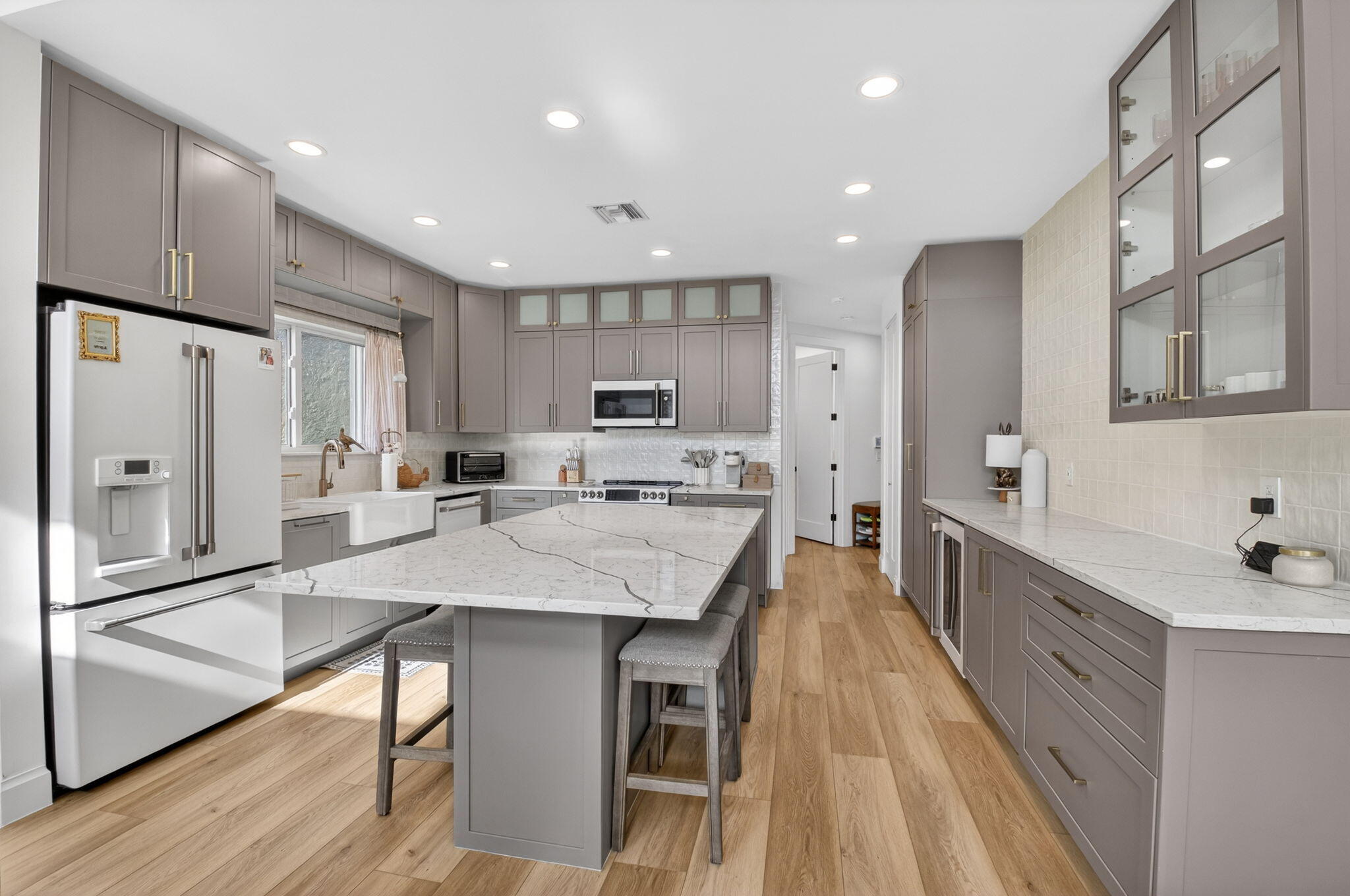 17108 Newport Club Drive Boca Raton, FL 33496 - Photo 4 of 39 a large kitchen with stainless steel appliances kitchen island granite countertop a refrigerator a sink dishwasher a stove and white cabinets with wooden floor