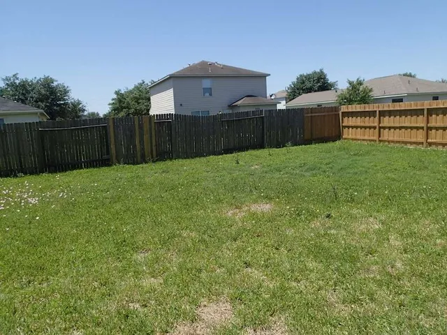 a view of a backyard with wooden fence