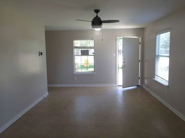 an empty room with windows and closet