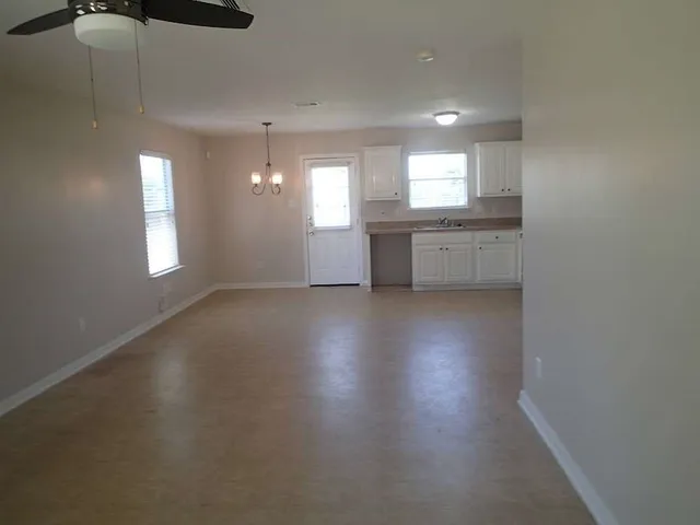 a view of empty room with wooden floor and window