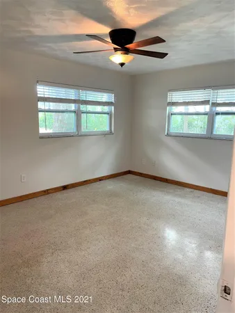 an empty room with a ceiling fan and carpet