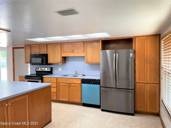 a kitchen with stainless steel appliances granite countertop a refrigerator a sink a stove a microwave and island