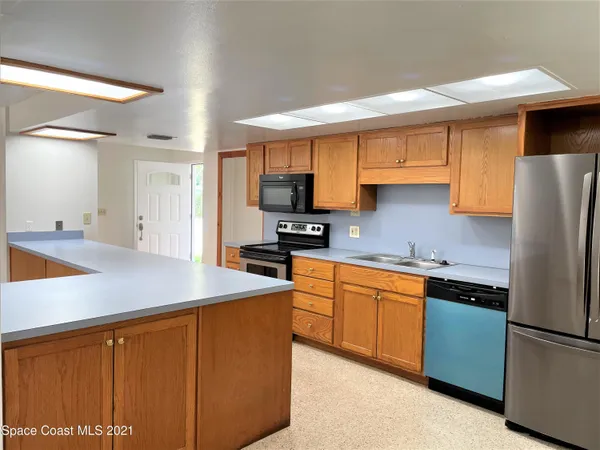 a kitchen with stainless steel appliances granite countertop a refrigerator sink and cabinets