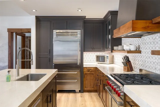 a kitchen with stainless steel appliances granite countertop a sink stove and refrigerator