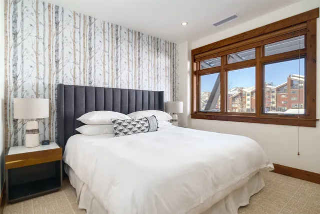 a large bed sitting in a bedroom next to a large window