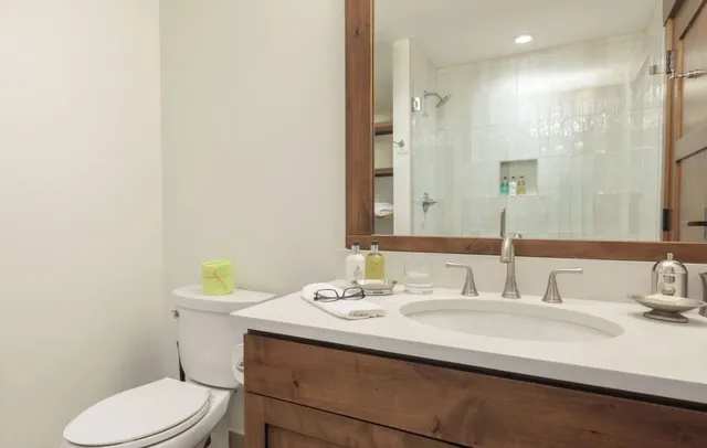 a bathroom with a sink toilet and a mirror