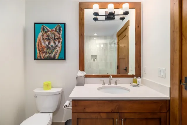 a bathroom with a sink a toilet and a mirror