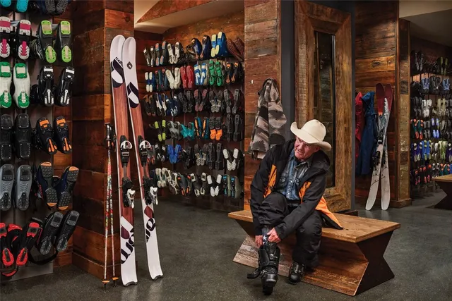 wooden floor with a large window and chandelier