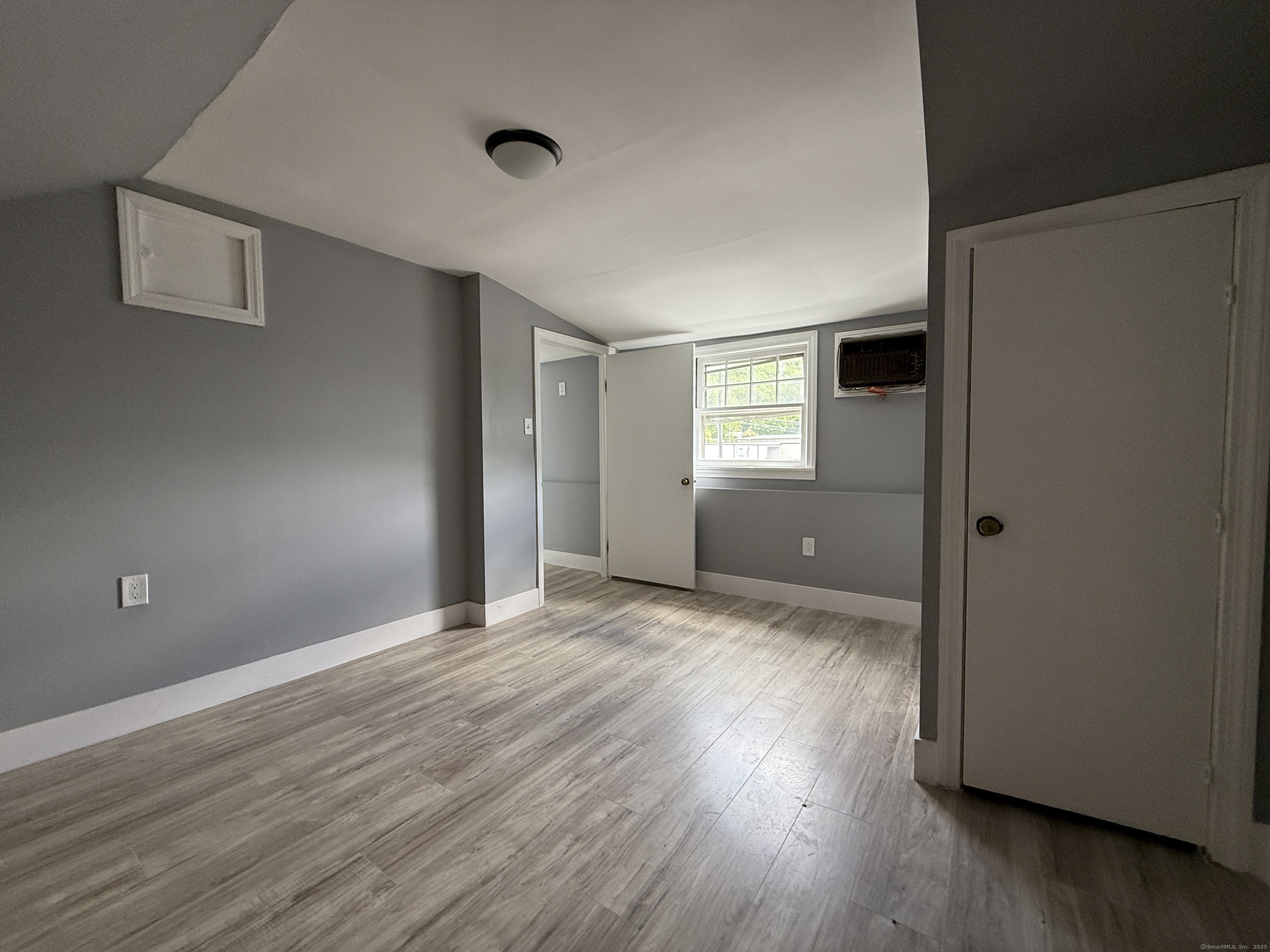 1402 Waterbury Road Thomaston, CT 06787 - Photo 12 of 13 a view of an empty room with wooden floor and a window