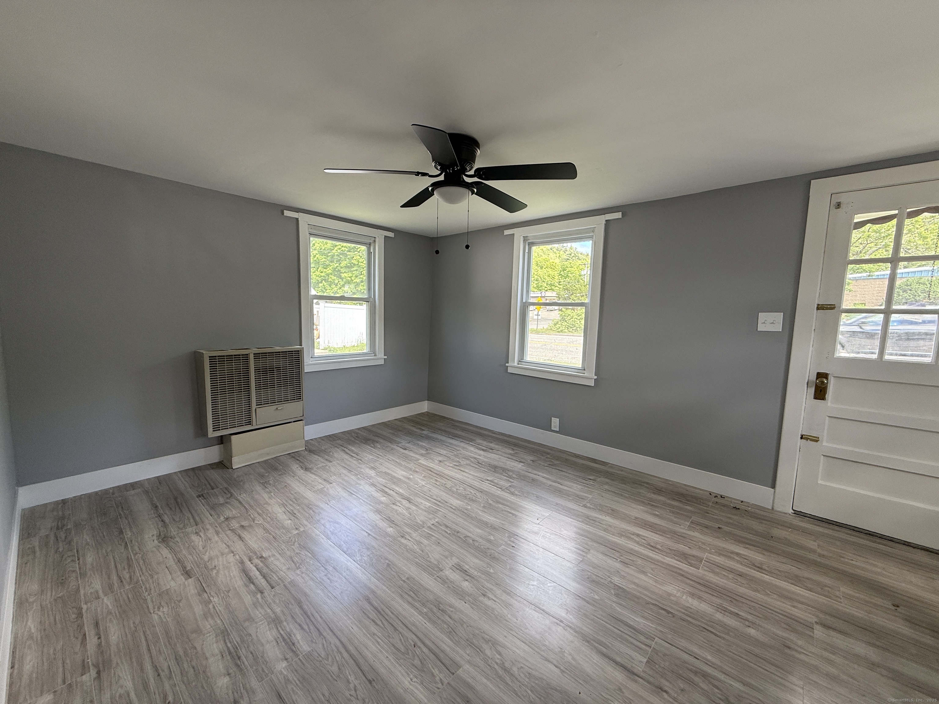1402 Waterbury Road Thomaston, CT 06787 - Photo 3 of 13 an empty room with wooden floor and windows