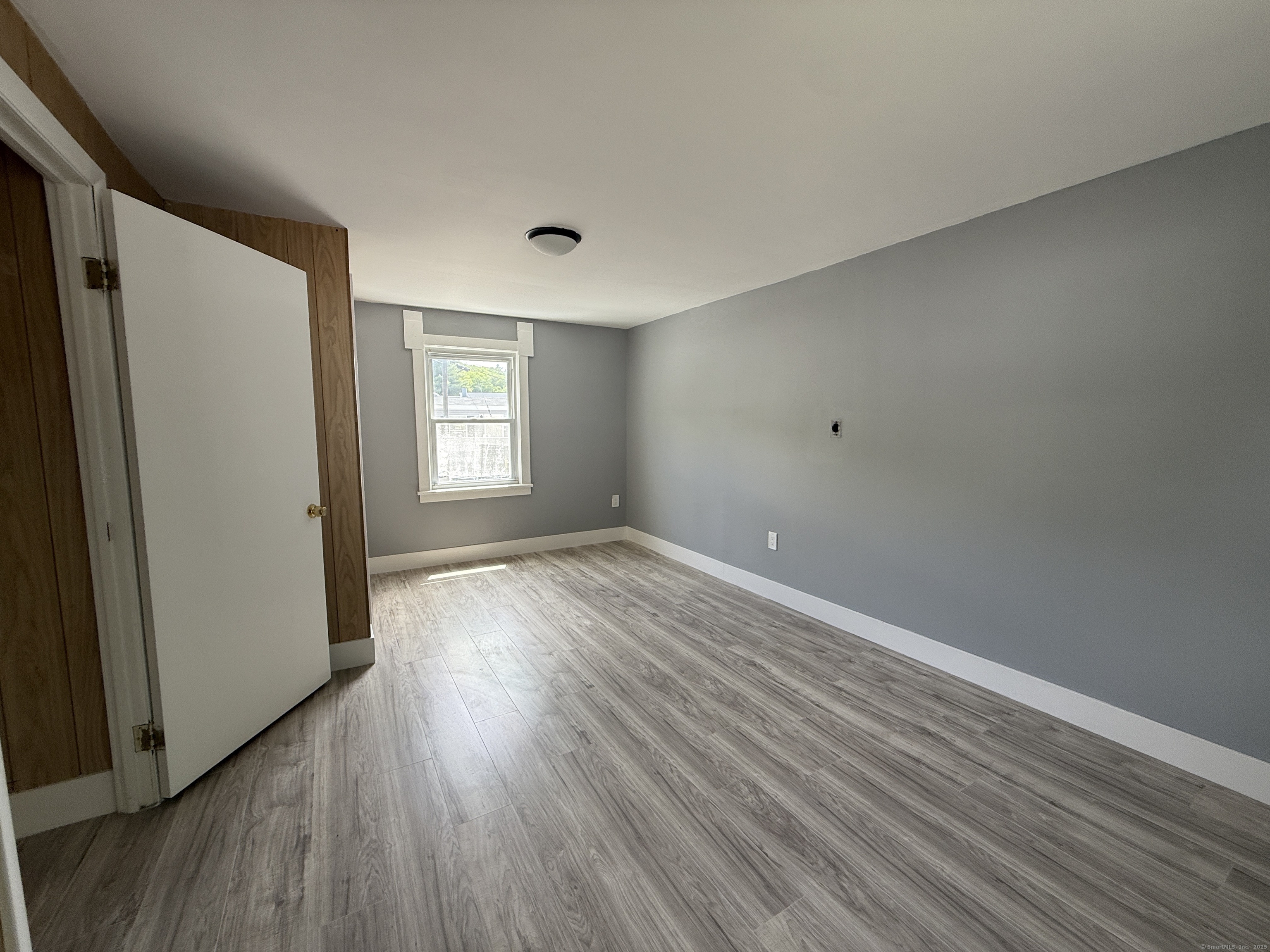 1402 Waterbury Road Thomaston, CT 06787 - Photo 7 of 13 an empty room with wooden floor and window