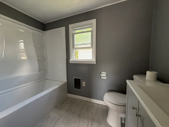 a white toilet sitting next to a bath tub