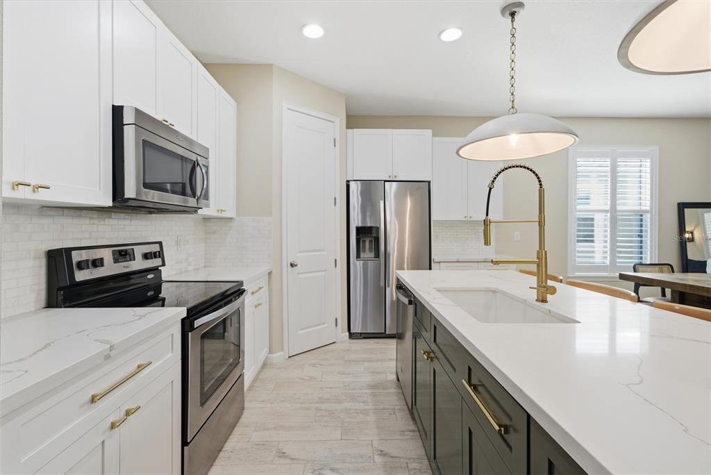 5232 Bentgrass Way Bradenton, FL 34211 - Photo 11 of 57 a kitchen with stainless steel appliances granite countertop a sink a stove and a refrigerator