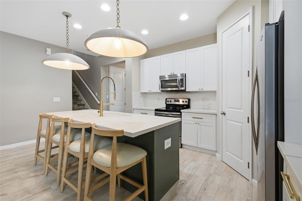 5232 Bentgrass Way Bradenton, FL 34211 - Photo 15 of 57 a kitchen with stainless steel appliances a table chairs and chandelier