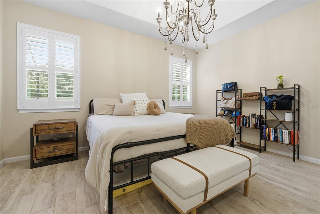 5232 Bentgrass Way Bradenton, FL 34211 - Photo 19 of 57 a bedroom with a bed and a chandelier