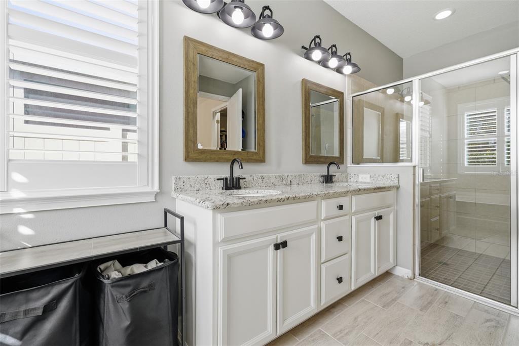 5232 Bentgrass Way Bradenton, FL 34211 - Photo 20 of 57 a bathroom with a granite countertop sink a mirror and a shower