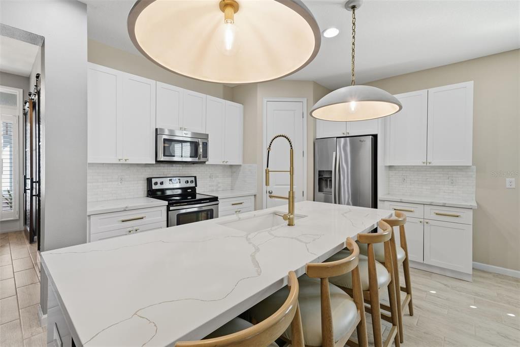 5232 Bentgrass Way Bradenton, FL 34211 - Photo 10 of 57 a kitchen with stainless steel appliances a table chairs and refrigerator