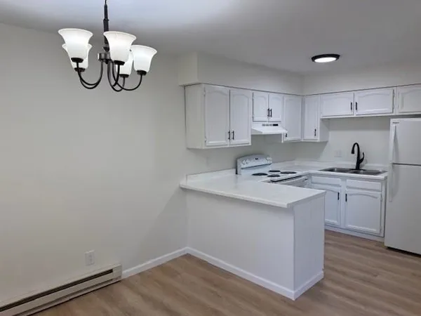 a kitchen with a sink cabinets and wooden floor
