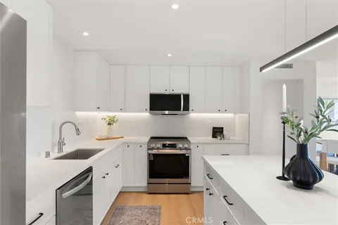 a kitchen with a table chairs refrigerator and cabinets