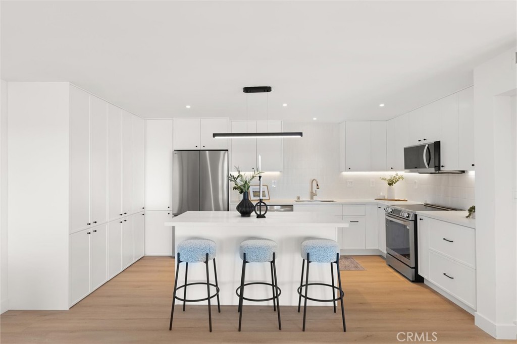 1200 East Ocean Boulevard, Unit 41 Long Beach, CA 90802 - Photo 12 of 35 a kitchen with a table chairs refrigerator and cabinets