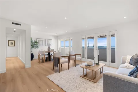 a kitchen with a stove a refrigerator and a dining table with wooden floor