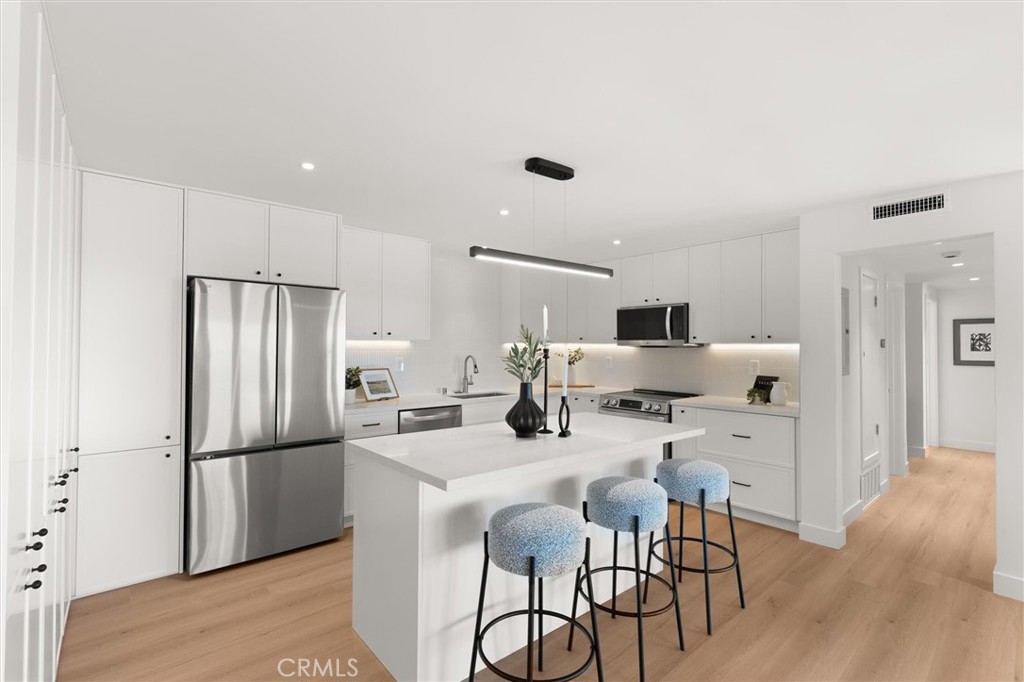 1200 East Ocean Boulevard, Unit 41 Long Beach, CA 90802 - Photo 10 of 35 a kitchen with stainless steel appliances kitchen island granite countertop a refrigerator and a stove top oven