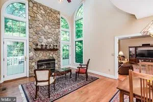 a living room with furniture a fireplace a flat screen tv and a large window