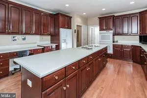 a kitchen with stainless steel appliances a sink dishwasher stove refrigerator and cabinets with wooden floor