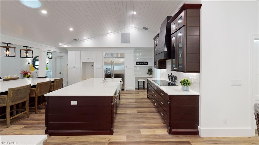 694 Regatta Court Naples, FL 34103 - Photo 12 of 33 a large room with kitchen island a lot of counter space a sink a window and chairs