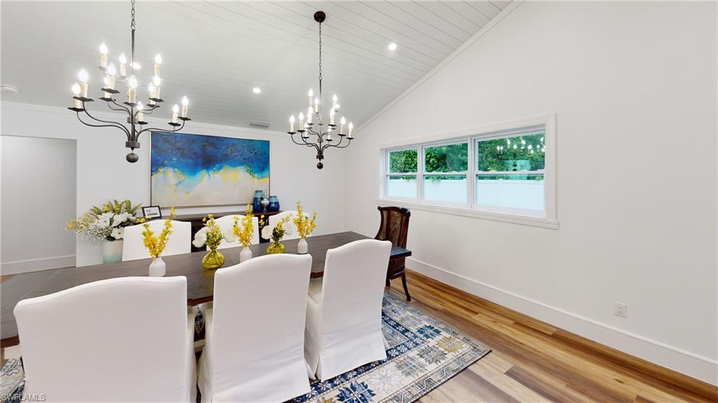 694 Regatta Court Naples, FL 34103 - Photo 14 of 33 a dining room with furniture a rug a chandelier and a rug