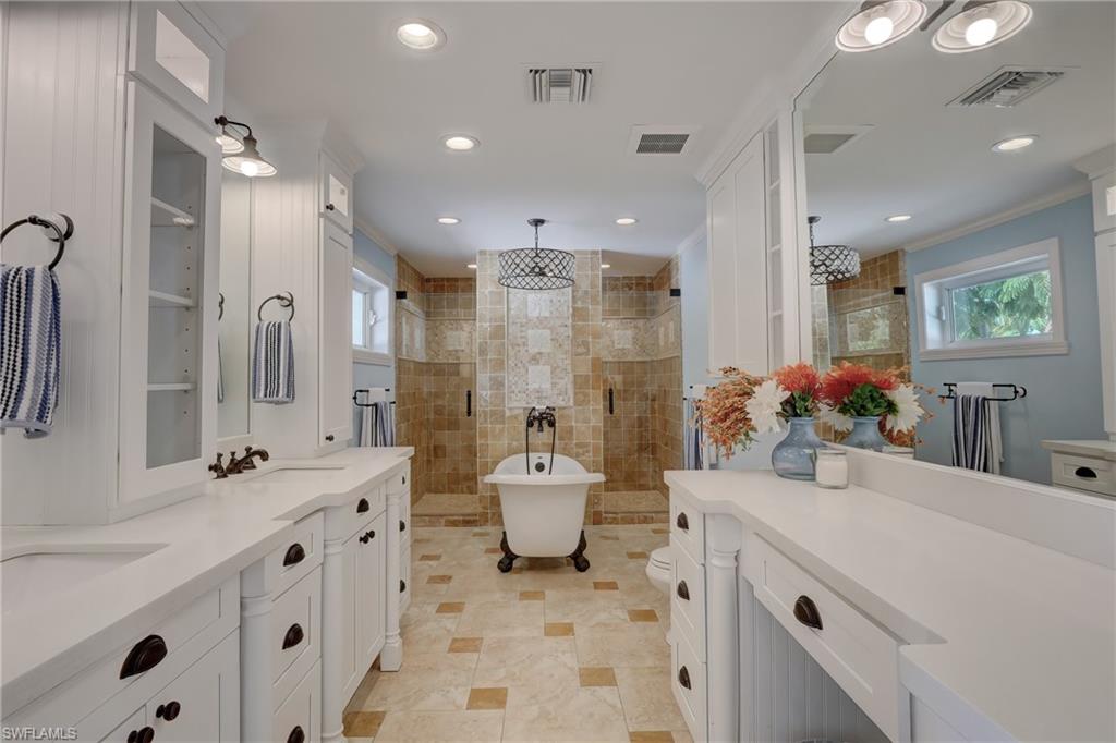 694 Regatta Court Naples, FL 34103 - Photo 17 of 33 a bathroom with a double vanity sink mirror double and shower