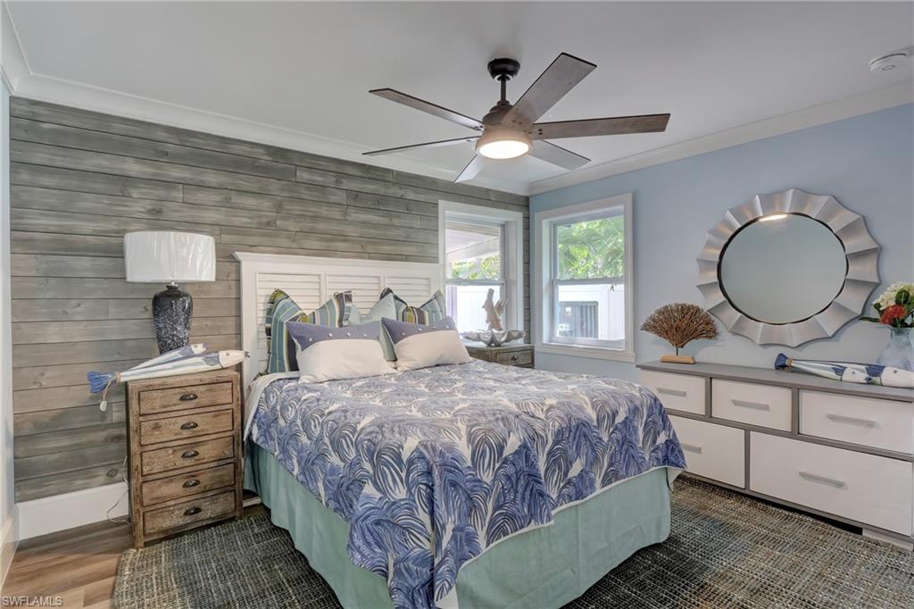 694 Regatta Court Naples, FL 34103 - Photo 20 of 33 a bedroom with a large bed and a chandelier