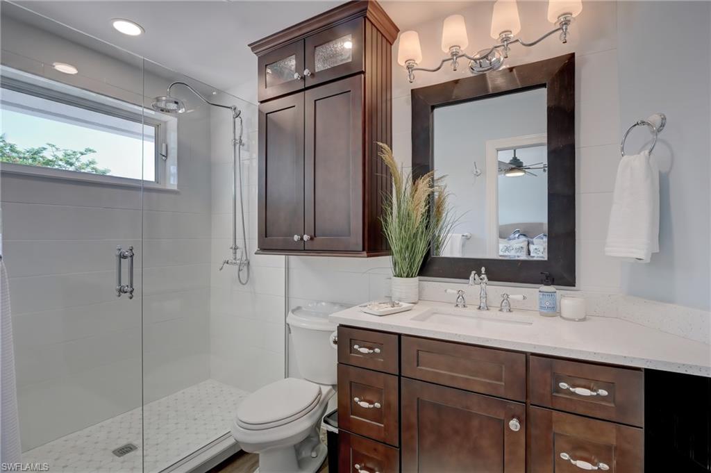 694 Regatta Court Naples, FL 34103 - Photo 25 of 33 a bathroom with a sink a toilet and a mirror