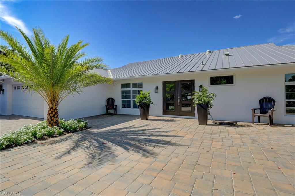 694 Regatta Court Naples, FL 34103 - Photo 33 of 33 a view of a house with potted plants and a large tree
