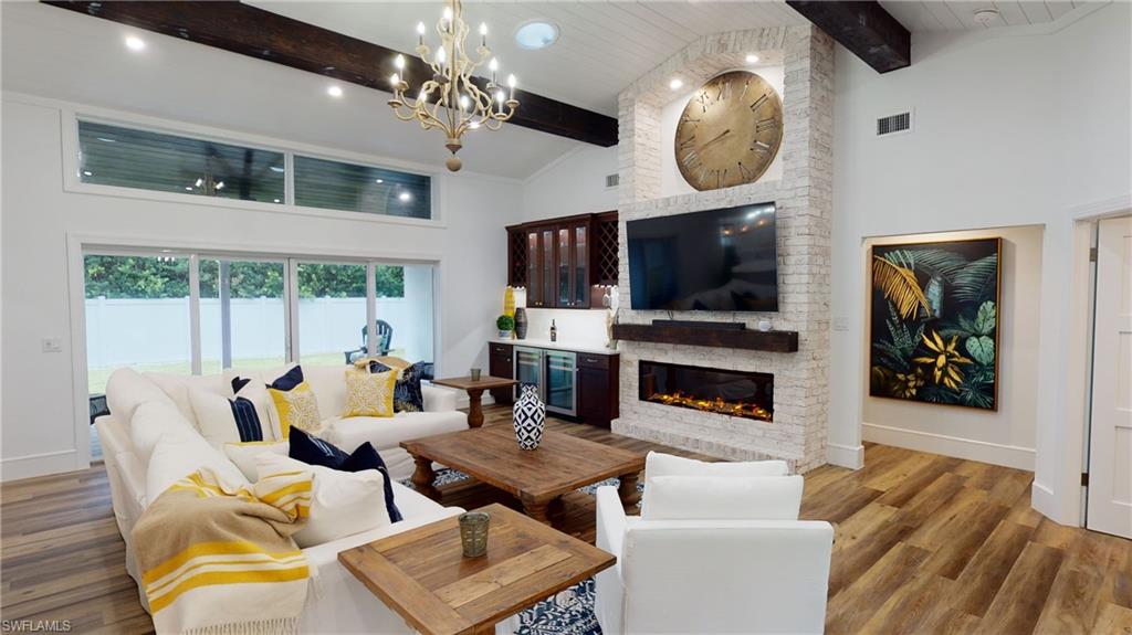 694 Regatta Court Naples, FL 34103 - Photo 4 of 33 a living room with fireplace furniture and a flat screen tv