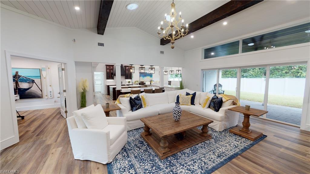 694 Regatta Court Naples, FL 34103 - Photo 5 of 33 a living room with furniture a chandelier and a table