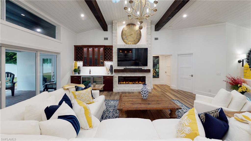 694 Regatta Court Naples, FL 34103 - Photo 7 of 33 a living room with furniture a fireplace and a flat screen tv