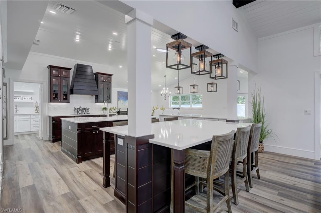 694 Regatta Court Naples, FL 34103 - Photo 8 of 33 a kitchen with stainless steel appliances kitchen island a table and chairs in it