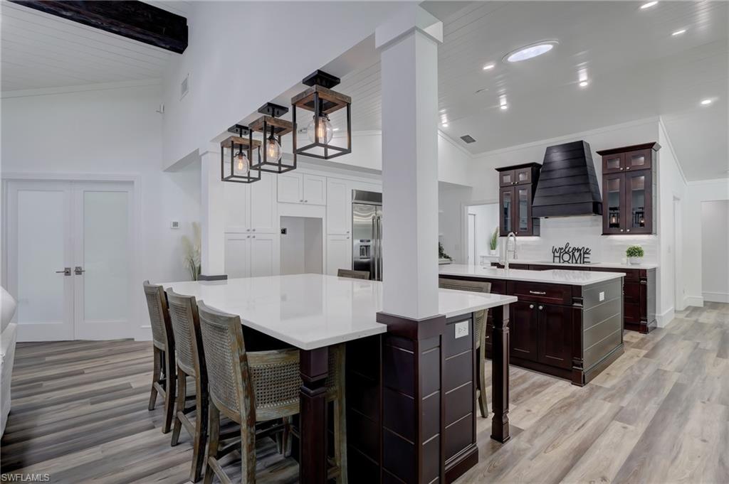 694 Regatta Court Naples, FL 34103 - Photo 9 of 33 a large kitchen with a table and chairs