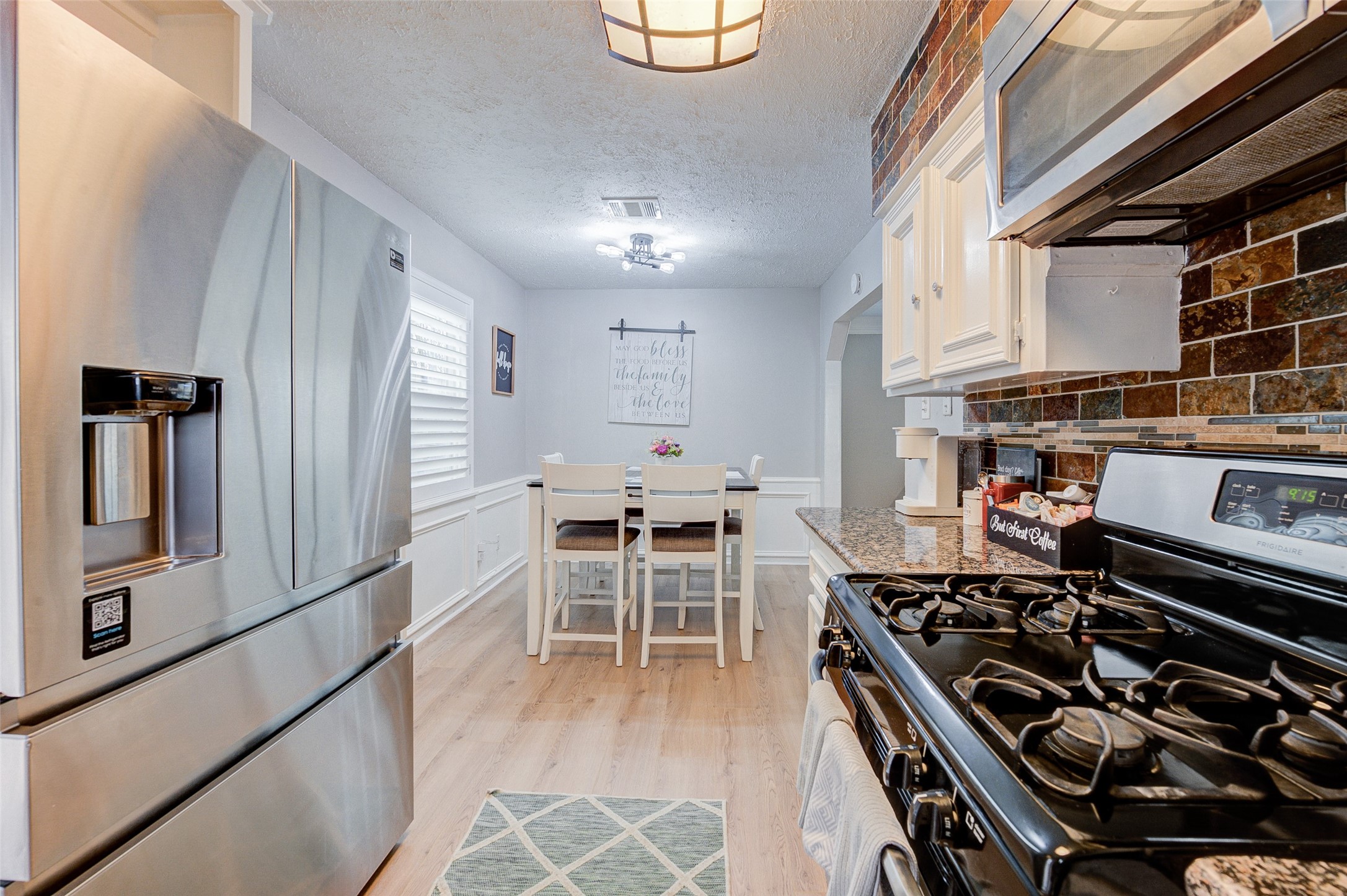 1207 Archer Street Houston, TX 77009 - Photo 13 of 30 a kitchen with stainless steel appliances granite countertop a stove a refrigerator and a dining table